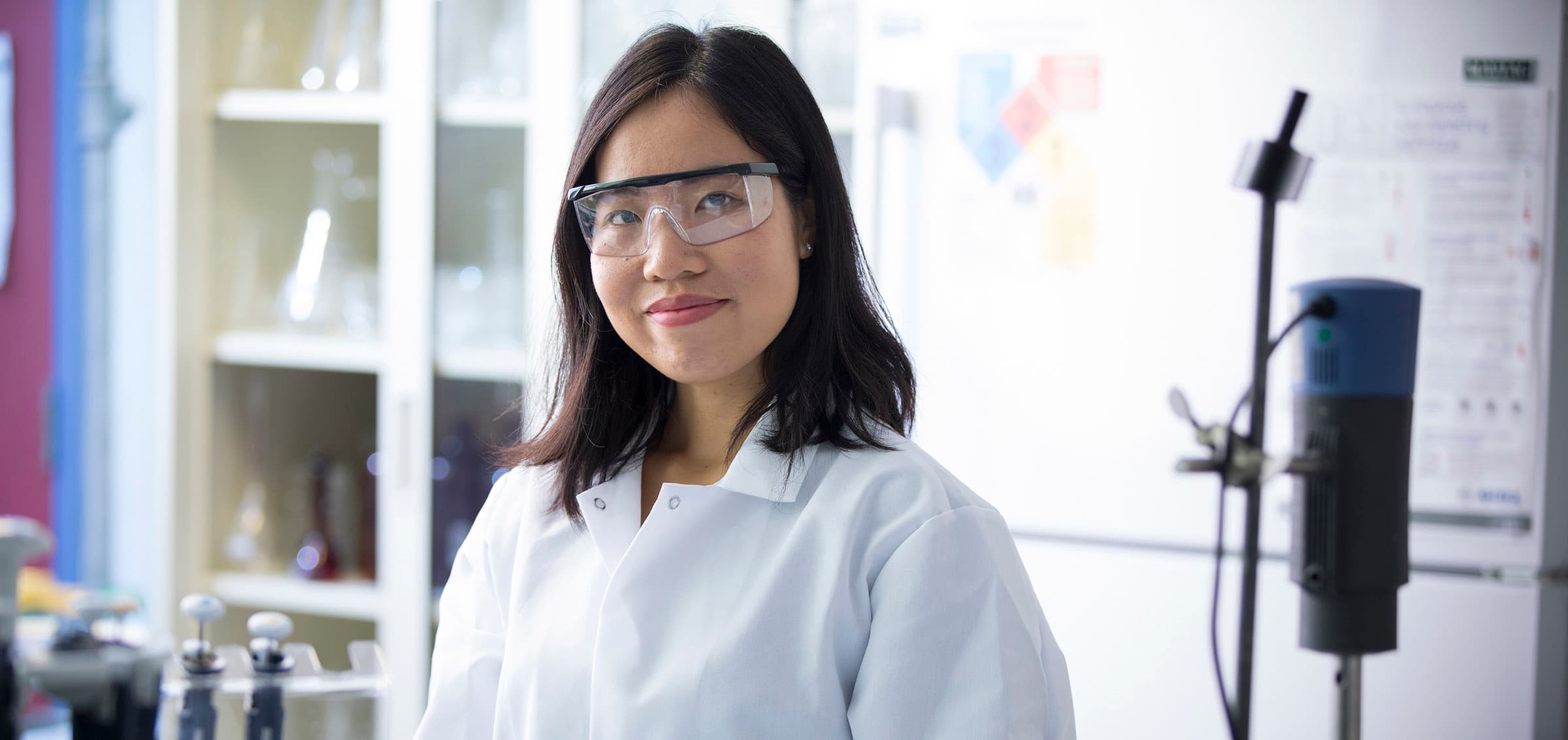 A person wearing a lab coat in a chemistry lab.