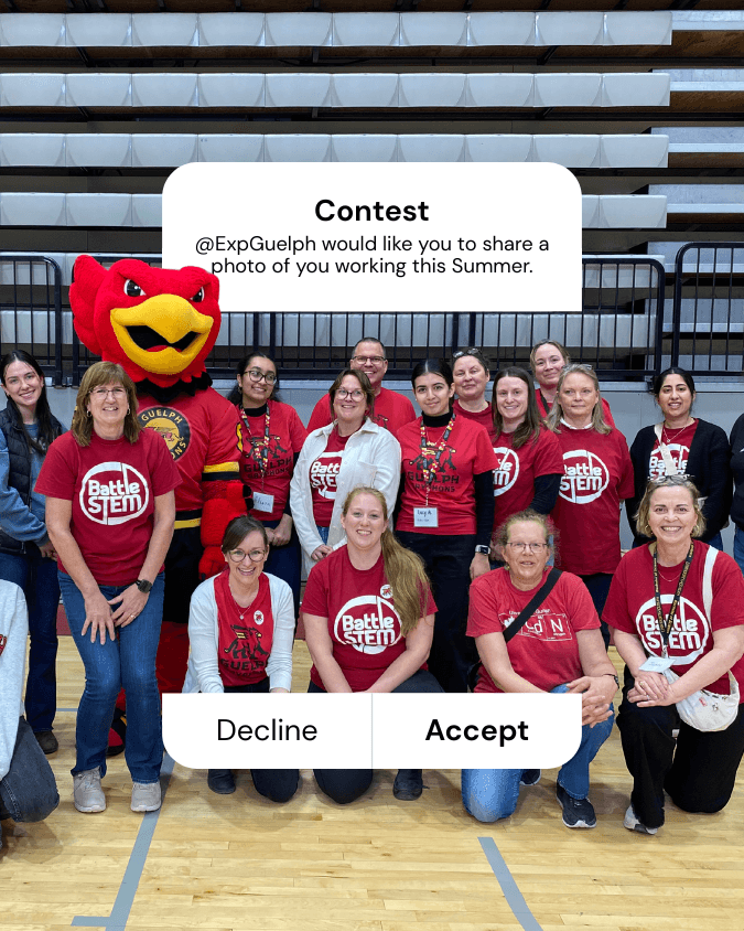 Gryph stands in a gym with a group of people wearing red shirts, posting for a photo. Contest: @ExpGuelph would like you to share a photo of you working this Summer.